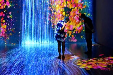 Couple staring at projected image in teamLab's City in a Garden at Future World